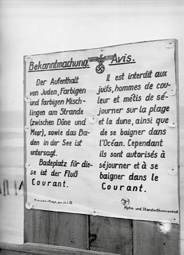 Summer 1940; racist and anti-Semitic sign at a French beach  