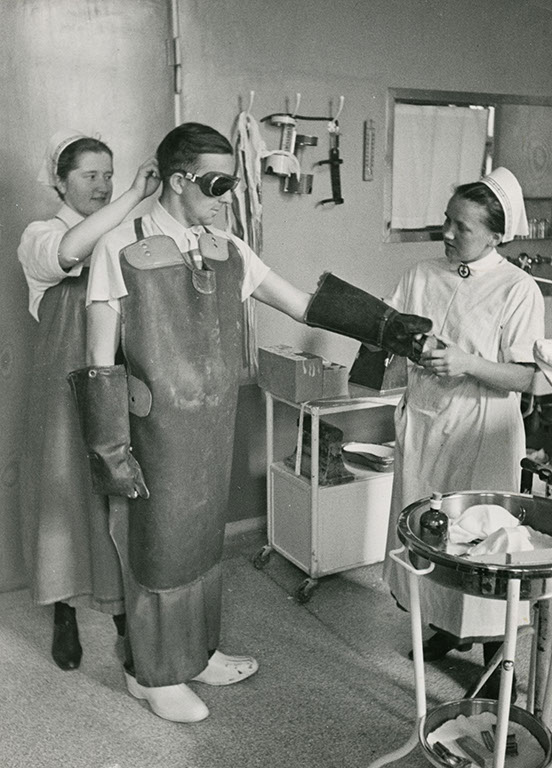 DRK nurses clothe a physician in radiation protection clothing